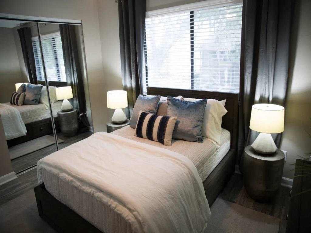 a bedroom with a large bed and a mirror