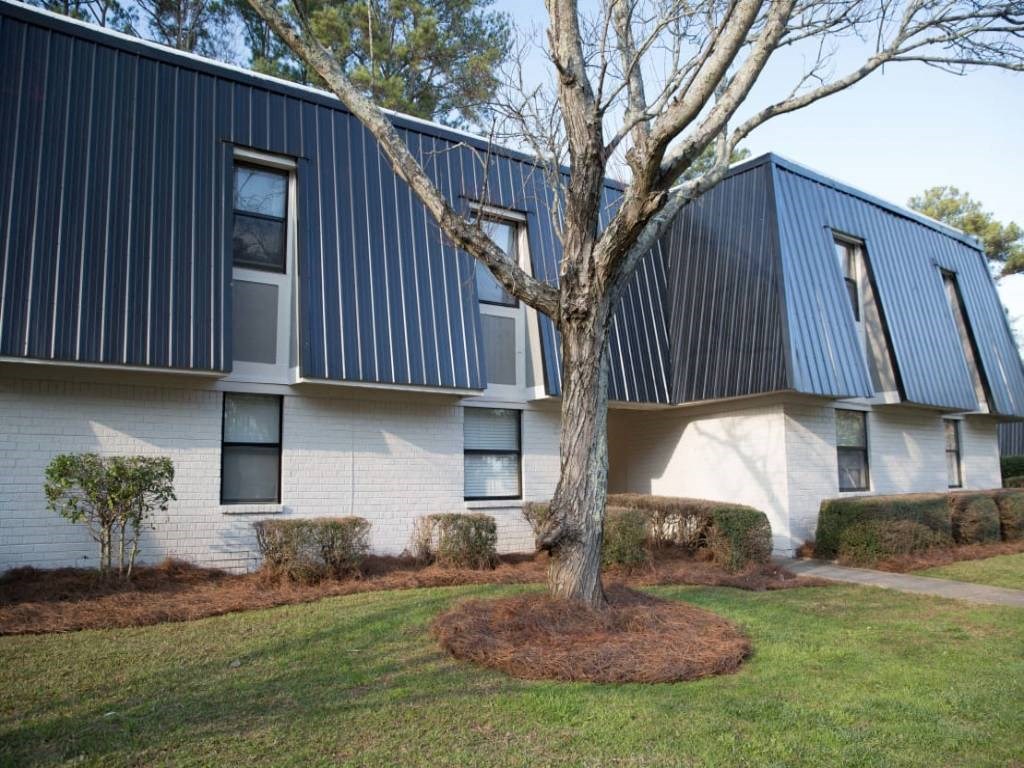 the exterior of a house with a tree in the yard