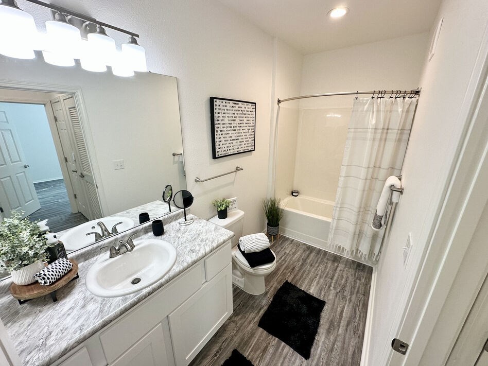 A bathroom with a sink, toilet, and shower.