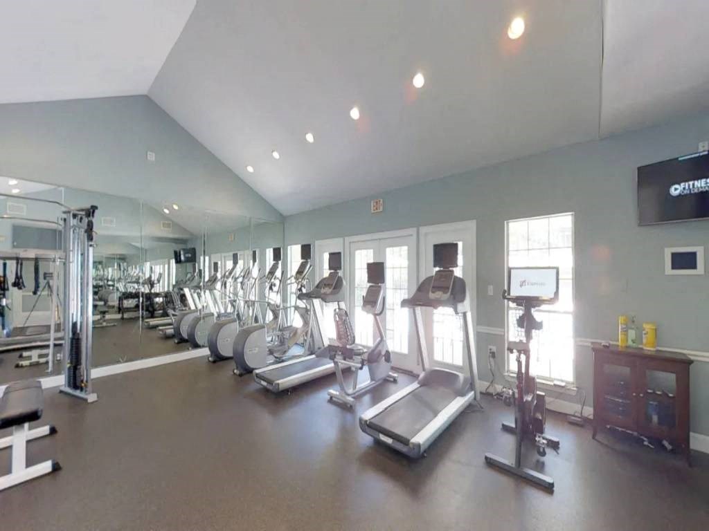 a gym with cardio equipment and windows in a building