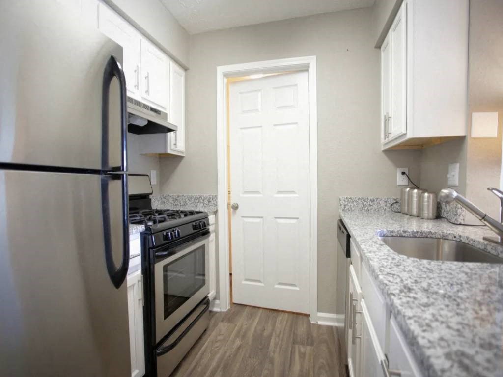 a kitchen with stainless steel appliances and marble counter tops