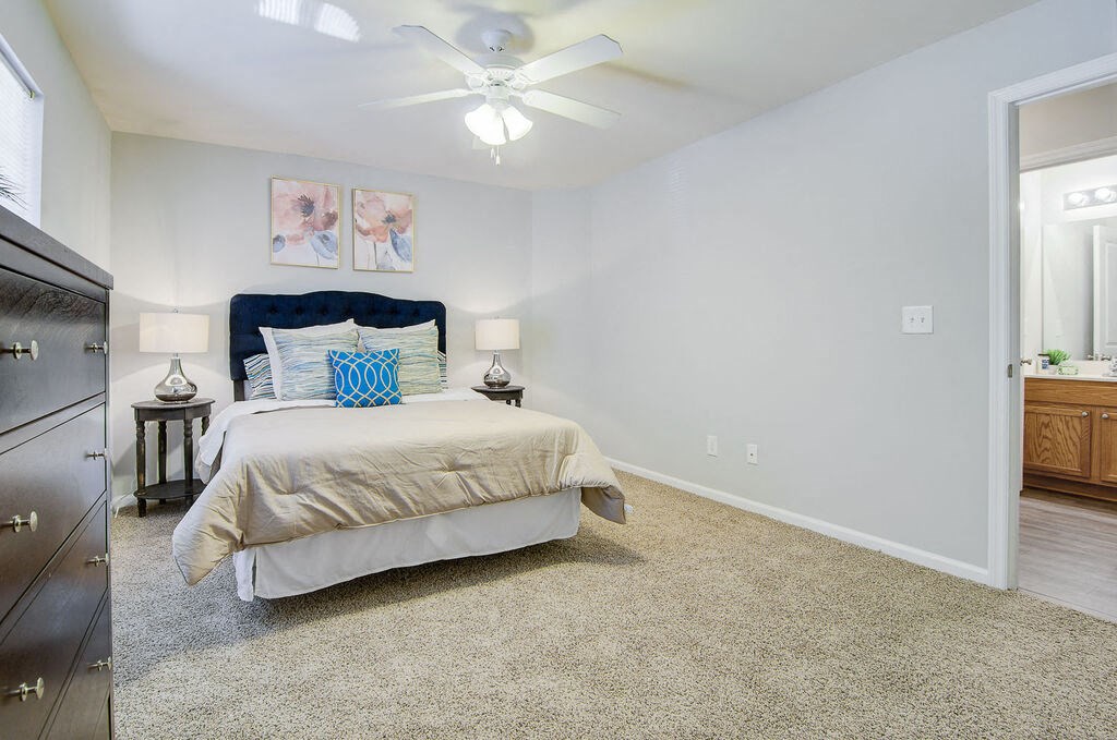 a bedroom with a bed and a ceiling fan at Enclave at West Ashley Apartments, Charleston,SC