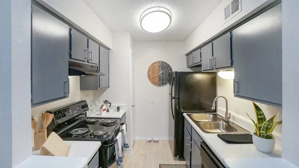 a kitchen with a stove top oven next to a sink  at Elevate at Huebner Grove, San Antonio Texas