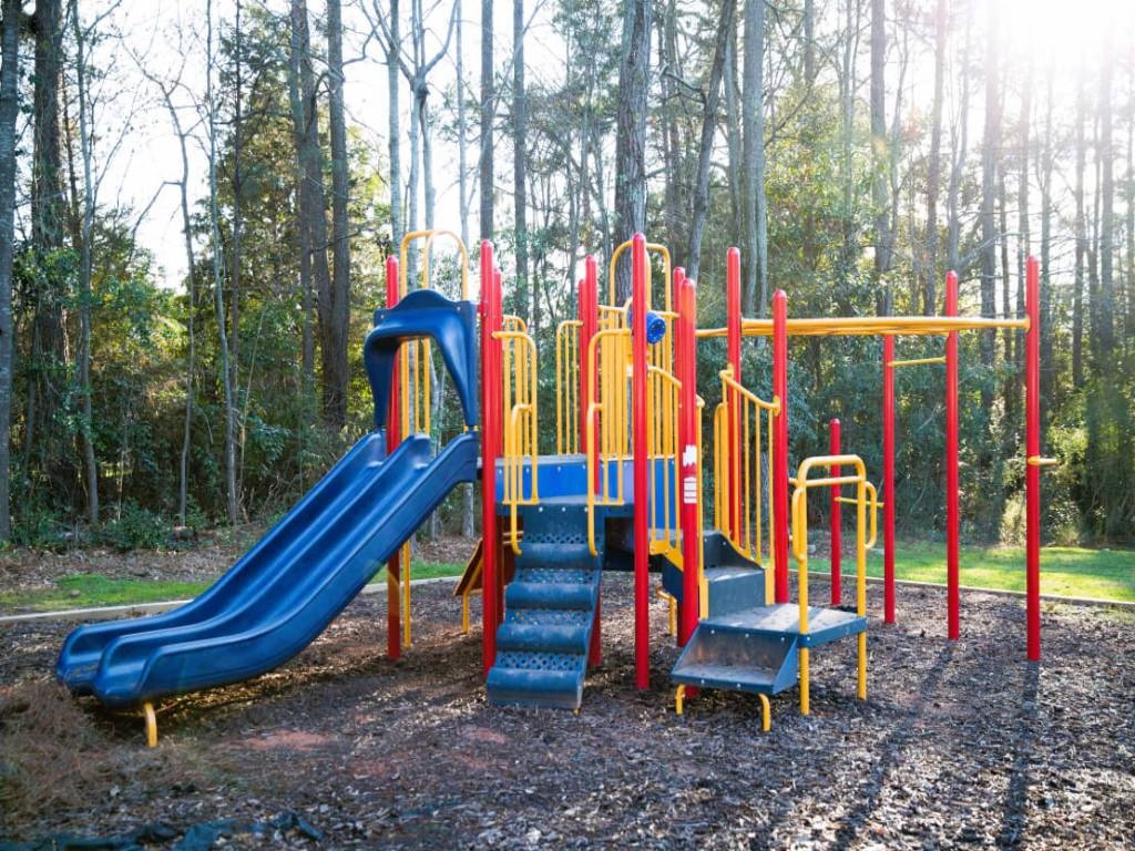 a playground with slides and benches in a park