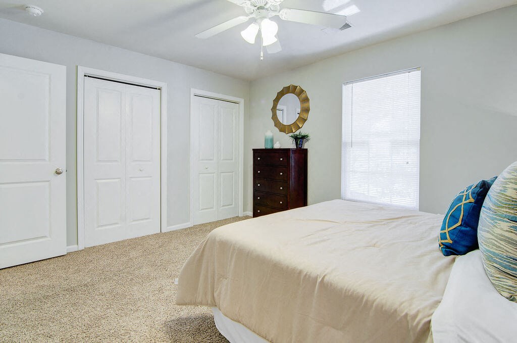 a bedroom with two closets and a ceiling fan at Enclave at West Ashley Apartments, Charleston,SC