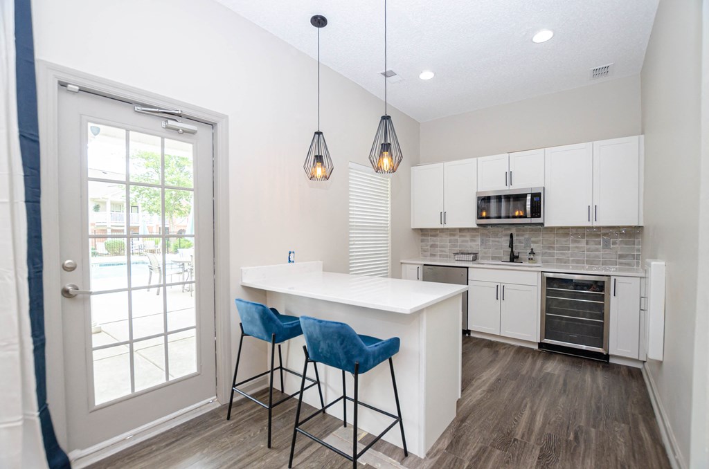 a kitchen with a large island and two blue bar stools