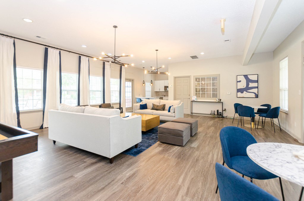 a living room with blue and white furniture and a kitchen