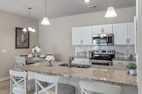 A kitchen with a granite countertop and white cabinets.