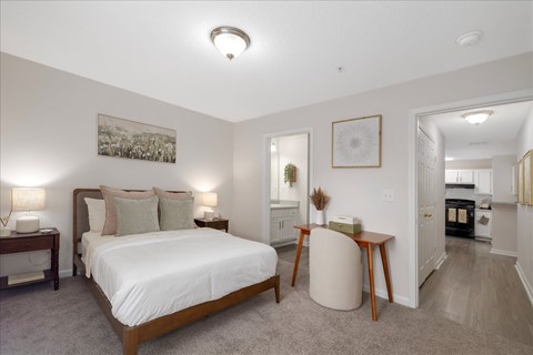 Bright bedroom with large windows and modern ceiling light at The Grove at Greenleaf Apartments in Conyers, GA