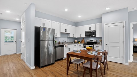 A kitchen with a table and chairs in the middle of the room.