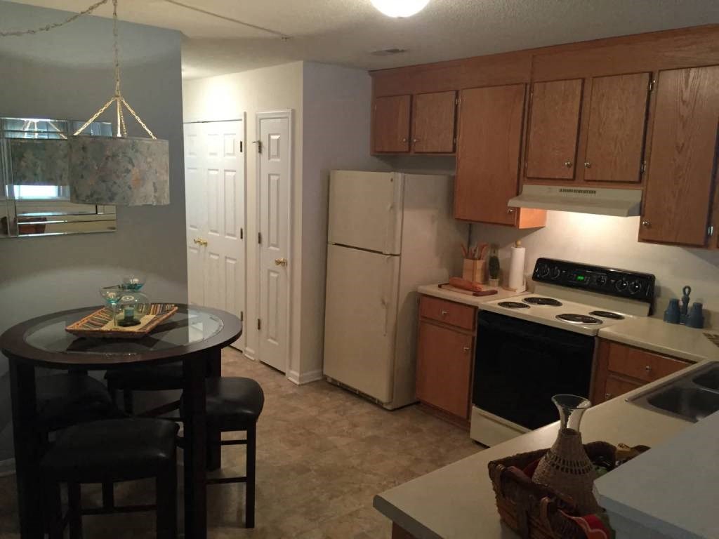 a kitchen with a table and a refrigerator