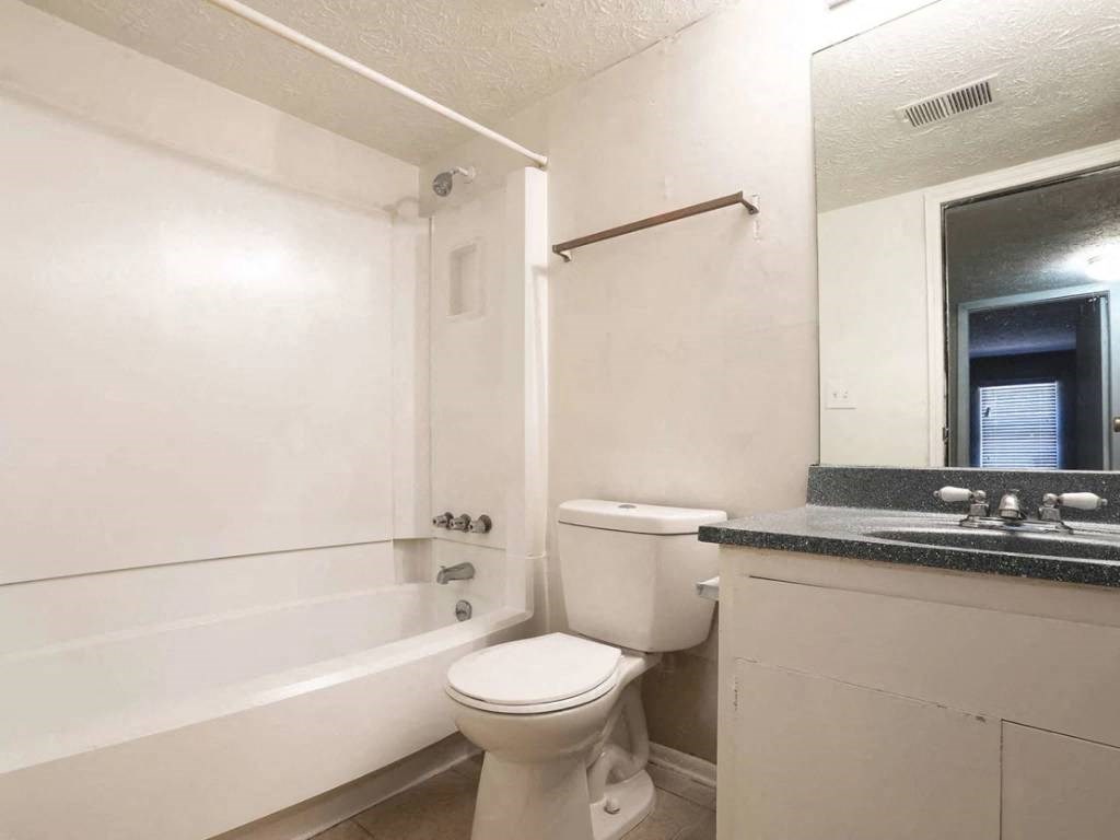 a bathroom with a toilet and a tub and a sink