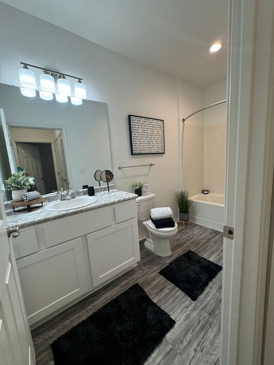 A bathroom with a white vanity and a white toilet.