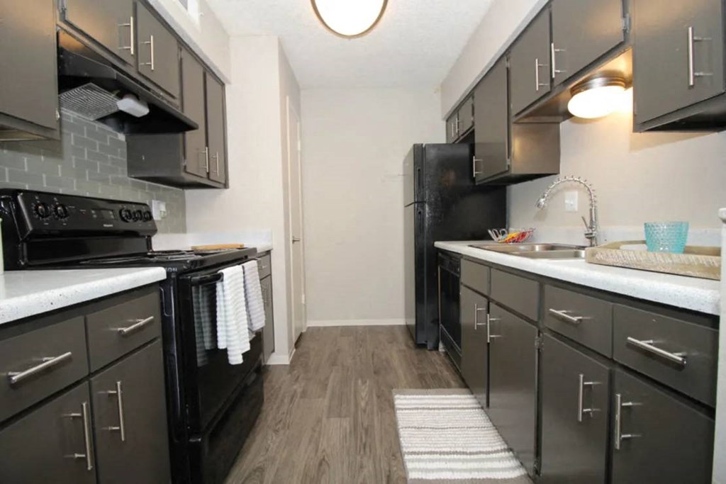 a kitchen with a stove top oven next to a sink at Elevate at Huebner Grove, San Antonio, Texas