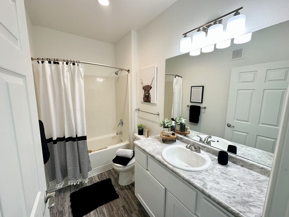 A bathroom with a white shower curtain and a white toilet.