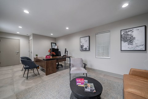 A modern office space with a desk, chairs, and pictures on the wall.