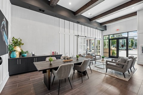 A modern dining room with a wooden table and grey chairs.