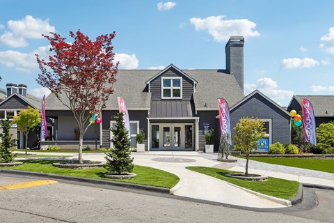 A grey building with a tree in front of it.