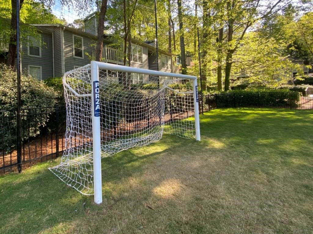 a soccer goal in a yard in front of a house