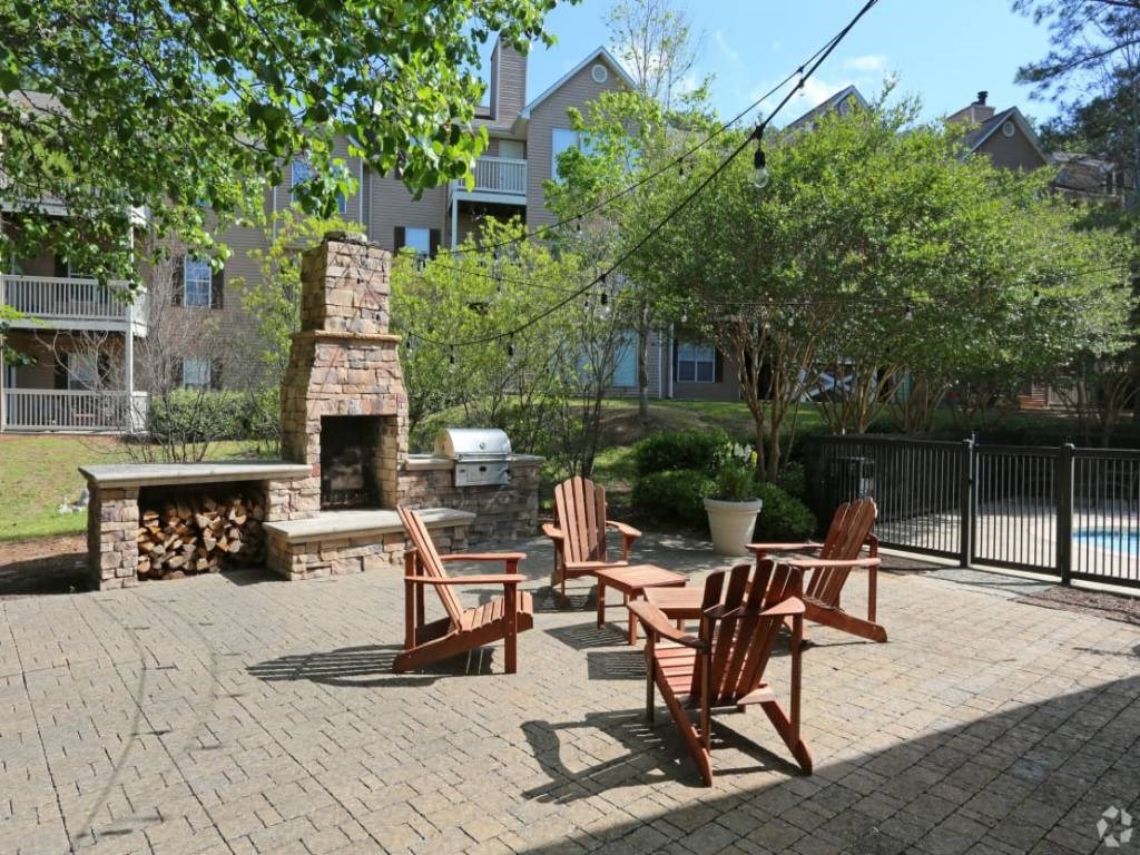 an outside patio with chairs and a fire pit