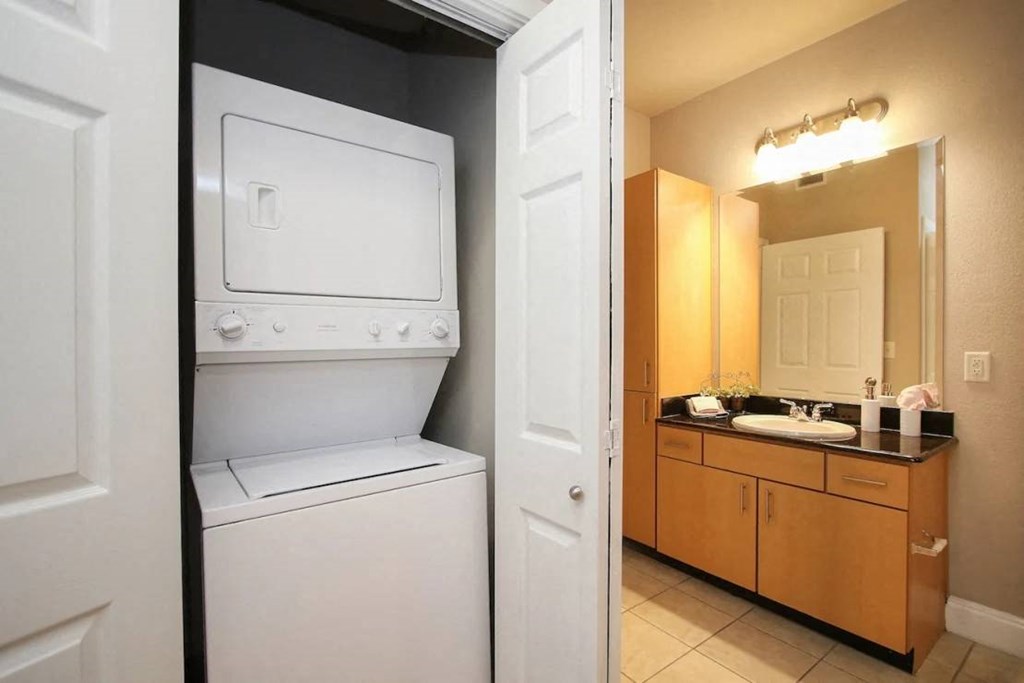 a washer and dryer in a bathroom next to a sink at Kings Cove, Texas, 77345