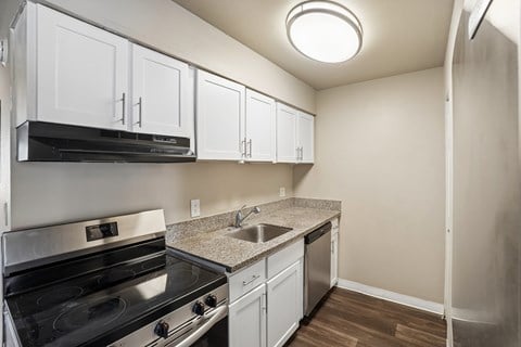 A kitchen with white cabinets and a black stove top oven.