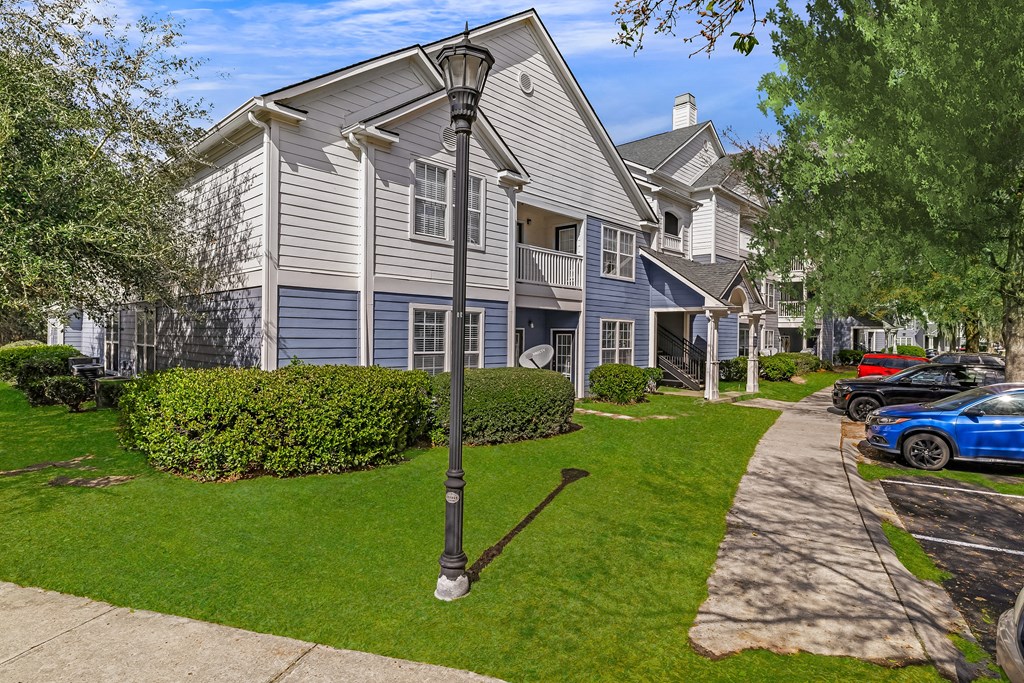 A residential area with a house, a street lamp and a parked car.