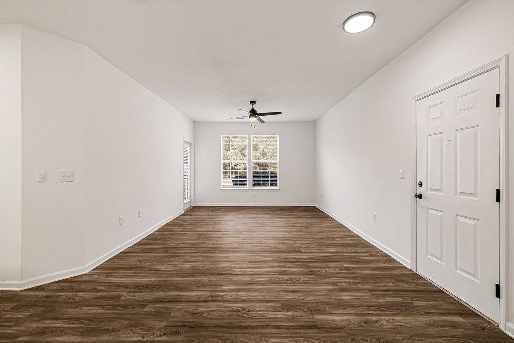 A room with wooden floors and a ceiling fan.