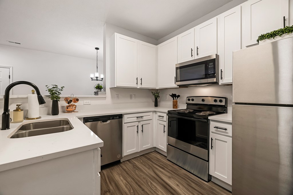 A modern kitchen with white cabinets and stainless steel appliances.