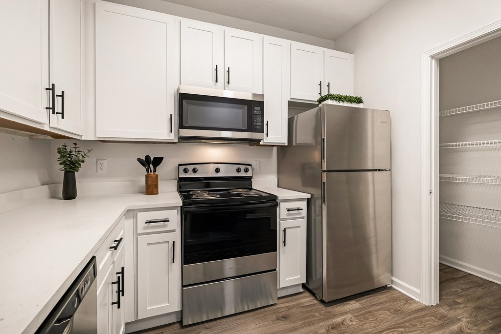 A kitchen with white cabinets and stainless steel appliances.
