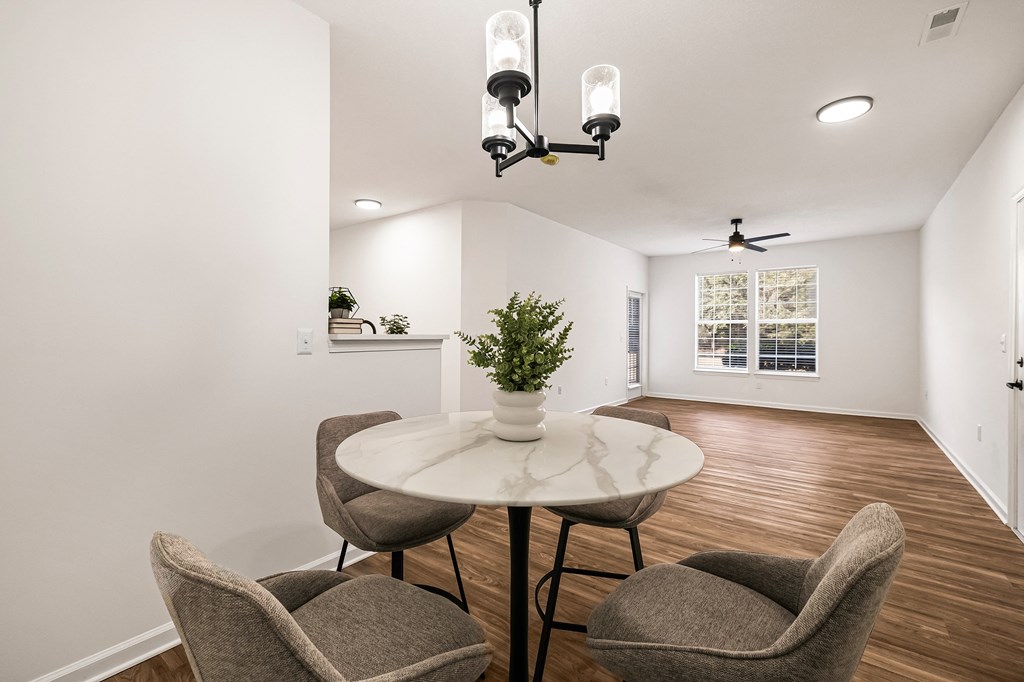 A dining room with a round table and chairs.