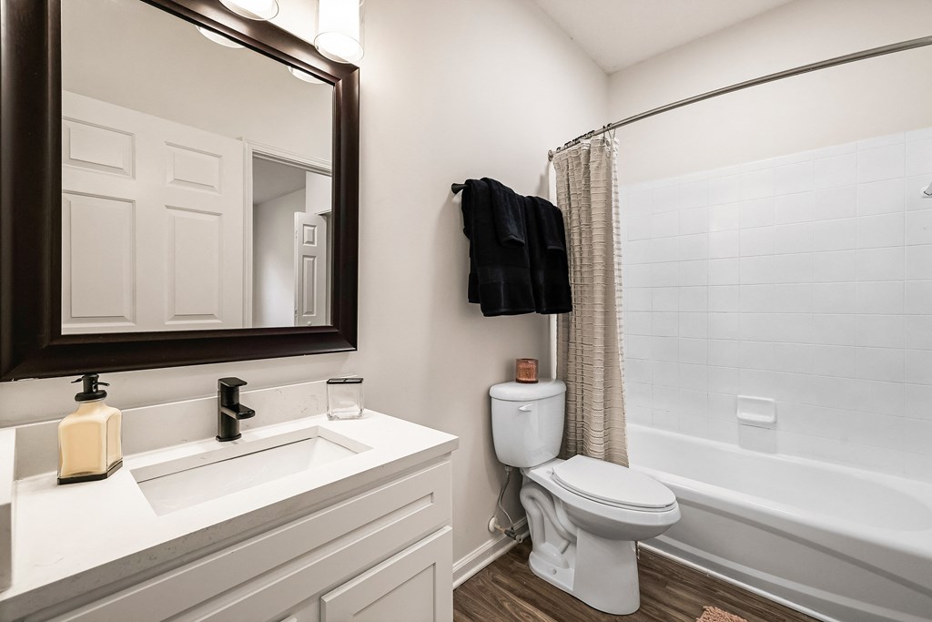 A white toilet sits next to a bathtub in a bathroom.