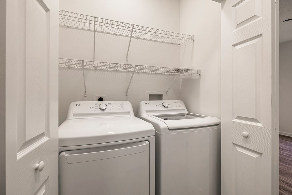 Two white front loading washing machines in a laundry room.