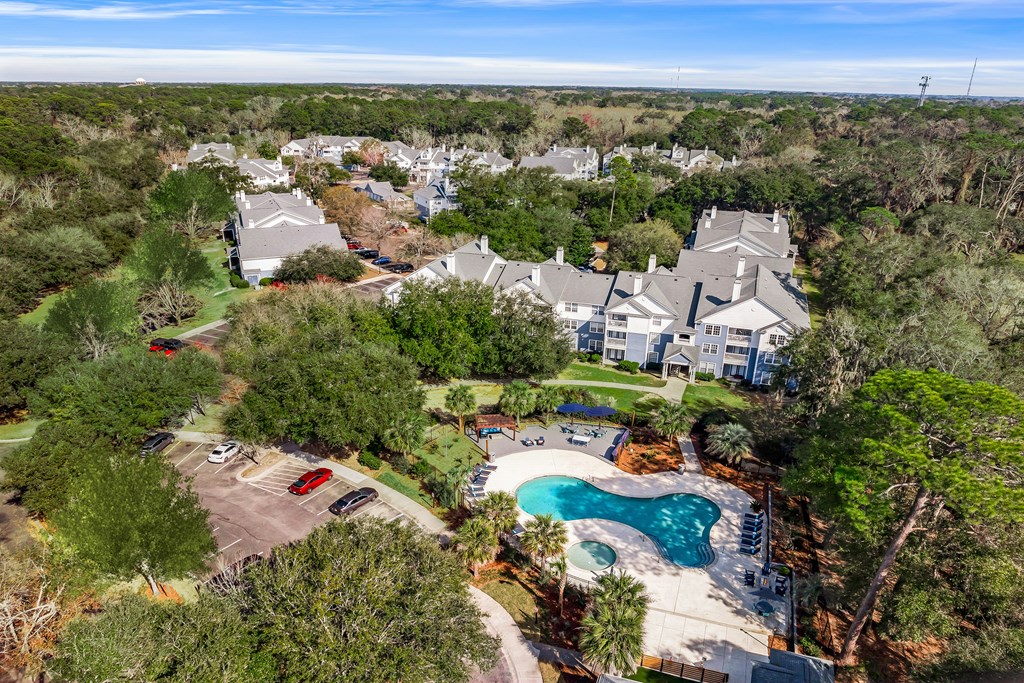 A bird's eye view of a residential area with a swimming pool.
