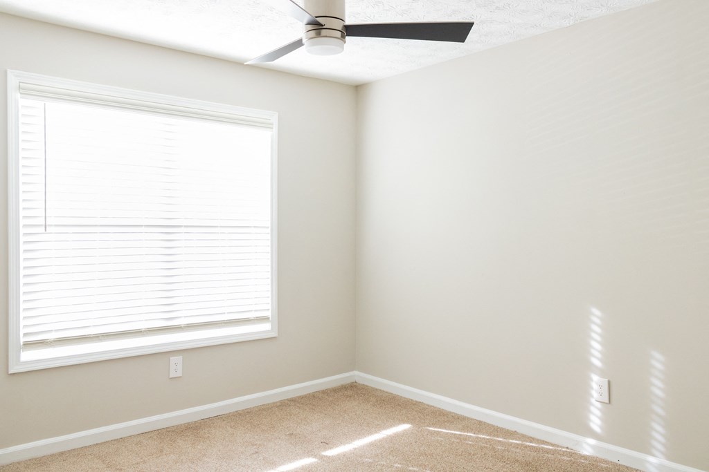 Large window with ceiling fan and carpet at Twin Springs Apartments, Norcross, GA