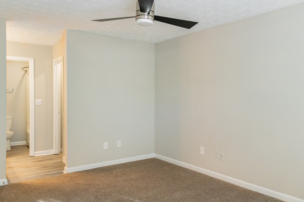 Bedroom with ceiling fan and carpet at Twin Springs Apartments, Norcross, GA
