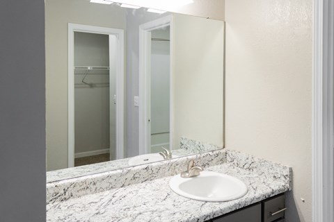 Bathroom countertop with large mirror at Twin Springs Apartments, Norcross, GA