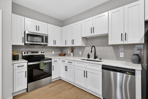 A kitchen with white cabinets and stainless steel appliances.