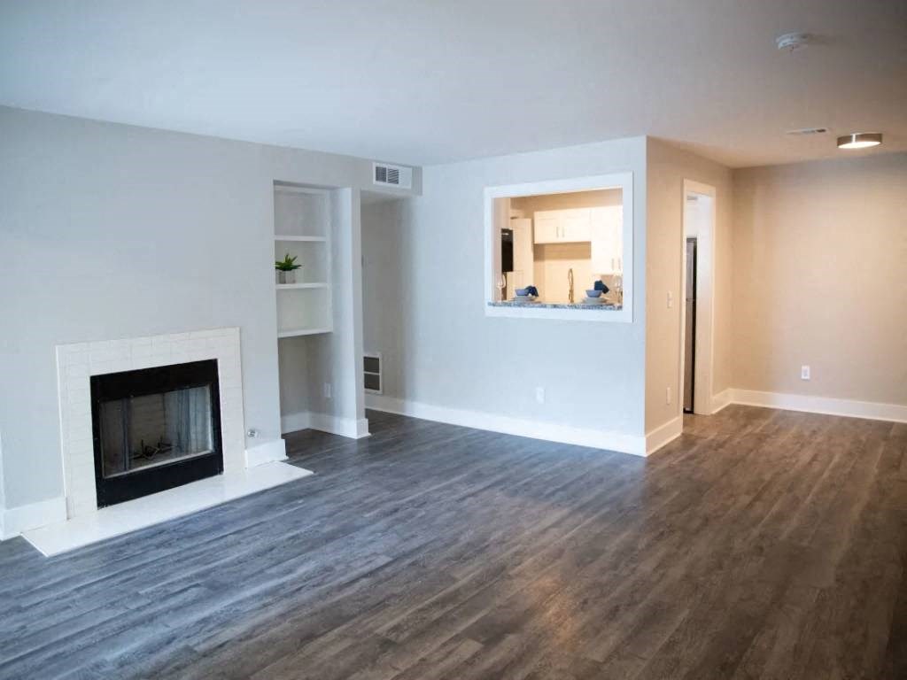 a living room with a fireplace and wooden floors