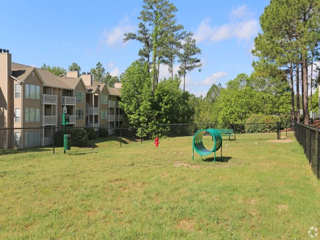 a large yard with a playground and apartment buildings