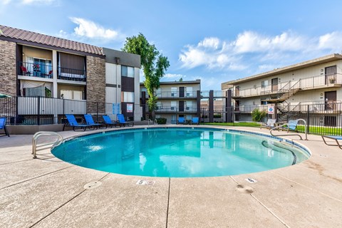 A swimming pool surrounded by apartment buildings.