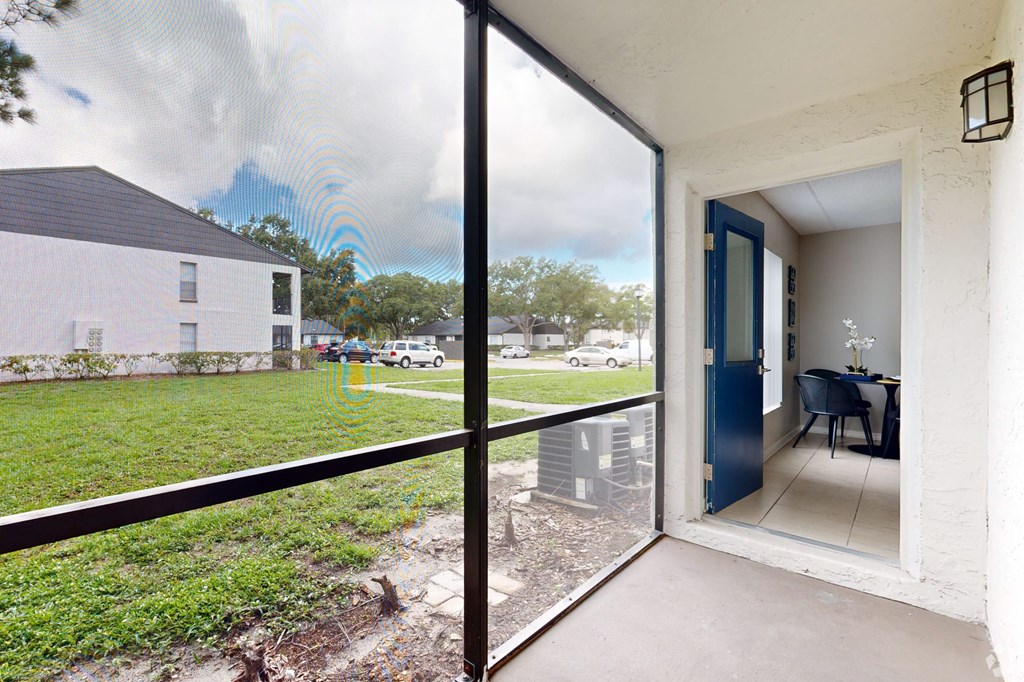 A patio with a table and chairs is visible through a glass door.