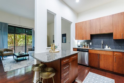 A kitchen with wooden cabinets and a marble countertop.