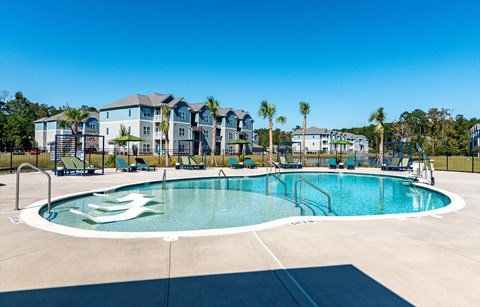 A swimming pool with a white lounge chair in the pool.