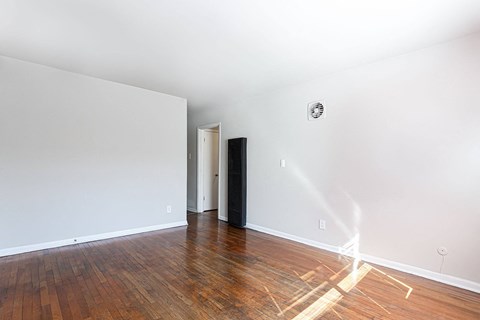 a living room with wood floors and white walls