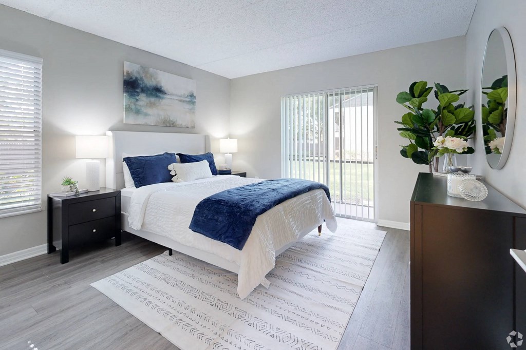 A bedroom with a large bed and a painting on the wall.