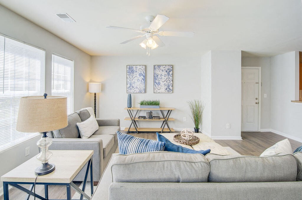 a living room with white walls and a ceiling fan at Enclave at West Ashley Apartments, Charleston,SC