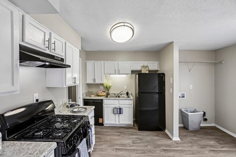 A kitchen with black stove top and white cabinets.