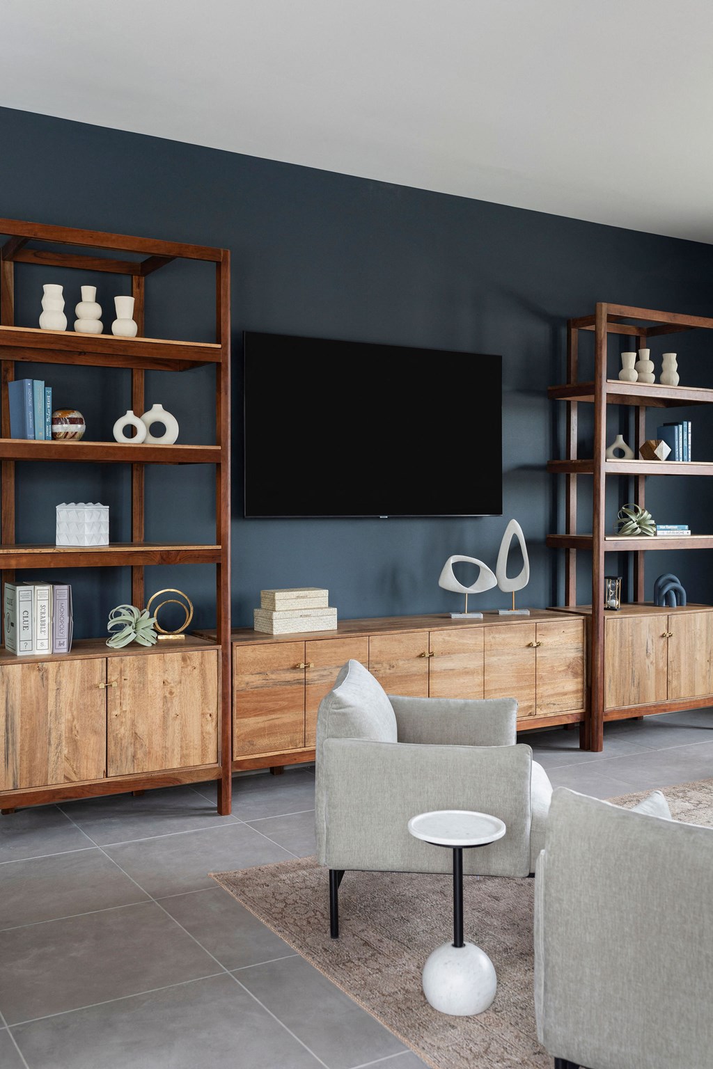a living room with a couch and a television on a blue wall at The Cannon, Murfreesboro Tennessee