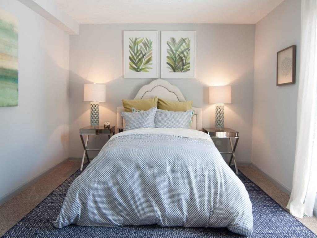 a bedroom with a bed and two paintings on the wall